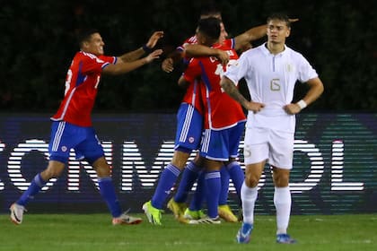 Los jugadores de Chile festejan el gol de Clemente Montes, el único del encuentro; en primer plano se lamenta el uruguayo Valentín Rodríguez.