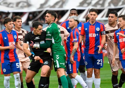 Los jugadores rodean al árbitro Sebastián Martínez Beligoy, durante el partido de la quinta fecha del Torneo Clausura 2025, que fue victoria de Platense sobre San Lorenzo, con un expulsado de cada lado