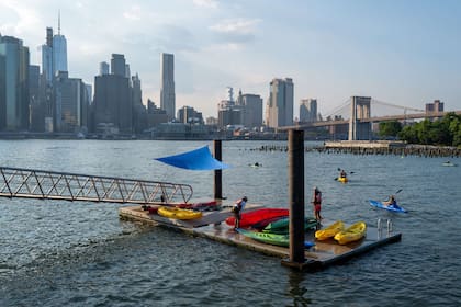 Los kayakistas se aventuran en el East River en una tarde sofocante en el distrito de Brooklyn de la ciudad de Nueva York