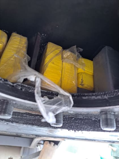 Los ladrillos de cocaína, envueltos en nylon amarillo en la unión del acoplado de un camión cargado con bananas de Ecuador