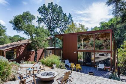 Como está inmersa en el bosque de Orinda (muy cerca de la Universidad de Berkeley), sólo desde el contrafrente empinado se distinguen bien los dos volúmenes unidos por un pasillo transparente de esta casa, que el arquitecto David Boone construyó para él y sus dos hijos en los años 70.