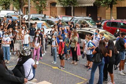 Los maestros saludan a los alumnos y a los padres con una mascarilla cuando llegan el 14 de septiembre de 2020 para el inicio del año escolar en la escuela secundaria técnica Luigi Einaudi en Roma