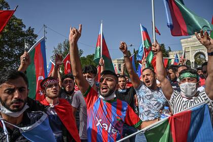 Los manifestantes azeríes gritan consignas y ondean banderas nacionales de Azerbaiyán mientras participan en una manifestación en Estambul el 4 de octubre de 2020