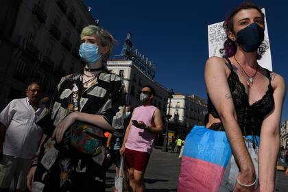 Los manifestantes con máscaras faciales participan en una protesta que pide más derechos para los transexuales en la Puerta del Sol en Madrid el 4 de julio de 2020