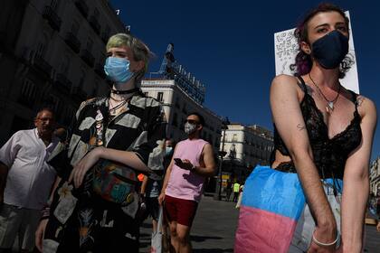 Los manifestantes con máscaras faciales participan en una protesta que pide más derechos para los transexuales en la Puerta del Sol en Madrid el 4 de julio de 2020