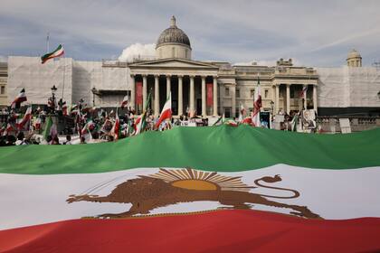 Los manifestantes exhiben una bandera gigante de Irán antes de la revolución mientras se reúnen en Trafalgar Square, en Londres, el sábado 16 de septiembre de 2023, cuando hoy se conmemora el aniversario de la muerte de Mahsa Amini en Irán.