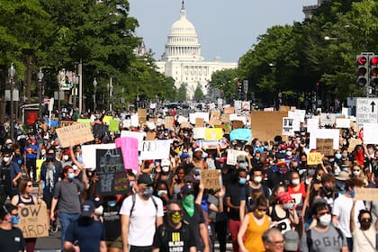 Los manifestantes marchan por la avenida Pennsylvania cerca del Trump International Hotel durante una protesta contra la brutalidad policial y la muerte de George Floyd, el 3 de junio de 2020 en Washington, DC