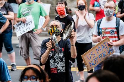 Los manifestantes se reúnen fuera del condominio del actual director general del correo de Estados Unidos Louis Dejoy el 15 de agosto de 2020 en Washington, DC