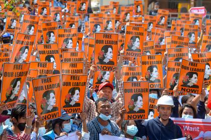 Los manifestantes sostienen carteles con la imagen del líder civil detenido Aung San Suu Kyi durante una manifestación contra el golpe militar en Naypyidaw el 28 de febrero de 2021