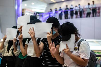 Los manifestantes tapan sus caras con papeles en blanco durante una protesta por la nueva ley de seguridad en un centro comercial en Hong Kong el 6 de julio de 2020