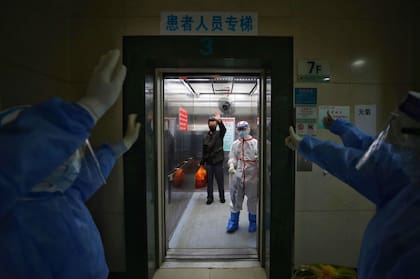 Los médicos de Wuhan saludan a un paciente recuperado de coronavirus mientras abandona el hospital