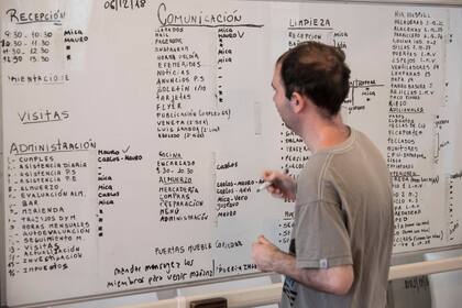 Los miembros anotan en un pizarrón las tareas que realizará cada uno