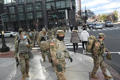 Los miembros de la Guardia Nacional cruzan una calle en Washington, DC el 18 de enero de 2021, ya que la seguridad se ha reforzado antes de la toma de posesión del presidente electo de los Estados Unidos, Joe Biden