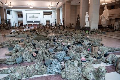Los miembros de la Guardia Nacional descansan en el Centro de Visitantes del Capitolio en Washington, DC, el 13 de enero de 2021