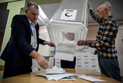 Los miembros de una comisión electoral local vacían una urna en un colegio electoral después del último día de las elecciones presidenciales de Rusia, que durarán tres días, en Moscú el 17 de marzo de 2024.