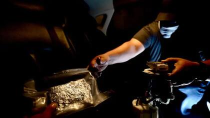Los miembros del cártel levantan los asientos traseros de un automóvil para esconder las pastillas de fentanilo en el depósito de combustible