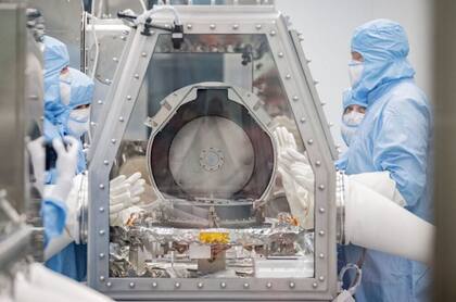 Los miembros del equipo de conservación de la NASA junto con los especialistas en recuperación de Lockheed Martin observan después de retirar con éxito la tapa del recipiente de retorno de muestras