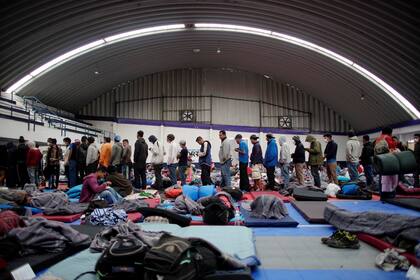 Los migrantes hacen fila para recibir comida en un refugio provisional durante su viaje hacia los Estados Unidos, en Puebla, México, el 28 de enero.
