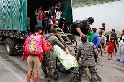 Los migrantes hondureños que intentaban llegar a los Estados Unidos se bajan de un vehículo militar cuando son enviados de regreso por las autoridades guatemaltecas en la frontera de El Florido entre Guatemala y Honduras