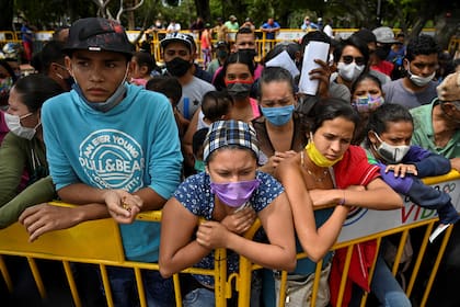 Los migrantes venezolanos que desean regresar a su país debido a la nueva pandemia de coronavirus, esperan en Cali, Colombia, la oportunidad de subir a un autobús que los llevará a la frontera, el 12 de mayo de 2020