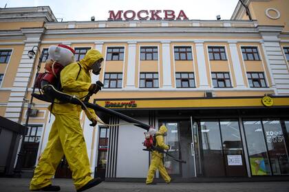 Los militares del Ministerio de Emergencias de Rusia que usan equipo de protección desinfectaron la estación de tren Savelovsky de Moscú el 26 de octubre de 2021, en medio de la pandemia del coronavirus