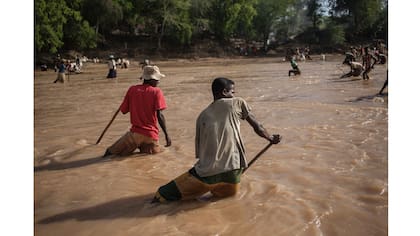 Los minero completan su trabajo de filtrado de la tierra en el río