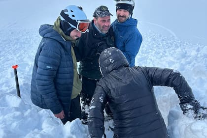 Los montañistas rescatistas Alfonso Lavado, Facundo Ureta y Mateo Archilla, junto al hombre que fue rescatado