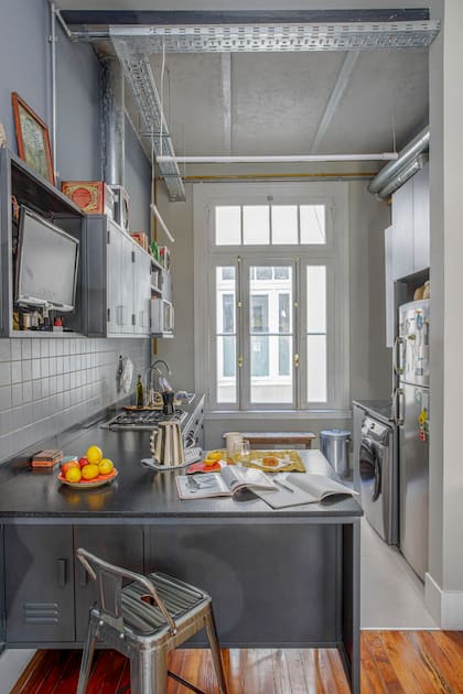Los muebles de cocina fueron diseñados por Minervini, en chapa pintada al horno para que no se oxiden. Piso de porcelanato ‘Urban Light Grey’ (Vite). En la barra, jarra de cerámica (NasoWare). Banqueta ‘Tolix’ (DeSillas).