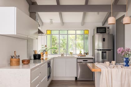 Los muebles de cocina fueron montados en la primera etapa de la obra. La barra es nueva (MTD Arquitectura), con tapa de madera.