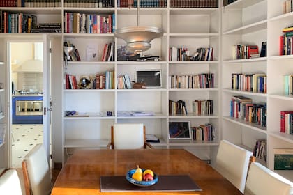 Los muebles son todos de los años 50 y 60, como así también las luminarias. La biblioteca oficia de comedor diario y también de antesala del living, se integra a la perfección.
