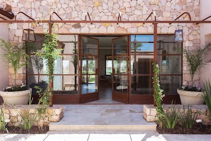 Los muros combinan tres tipos diferentes de piedra. Durante la obra, se hicieron paredes de muestra variando las proporciones hasta llegar a la fórmula final. Tras el frente ciego, aparece el patio de acceso. Tiene piso de platillo de mármol Travertino y una gran puerta de hierro que se prolonga en