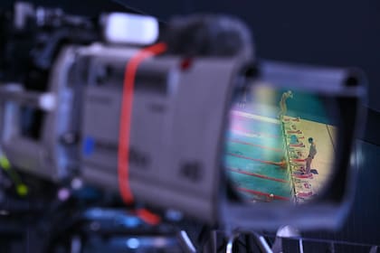 Los nadadores se reflejan en la lente de una cámara de televisión durante una sesión de práctica en el Centro Acuático de Tokio en Tokio el 24 de julio de 2021, durante los Juegos Olímpicos de Tokio 2020.