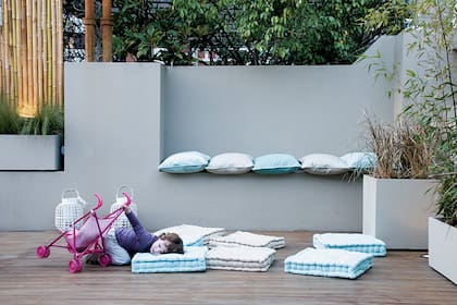 Los nichos en la medianera de esta terraza fueron aprovechados para improvisar unos asientos. Las cañas de bambú es un recurso estético que sirve para aumentar la privacidad