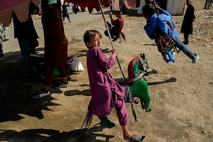 Los niños afganos disfrutan de un paseo en un carrusel en Kabul