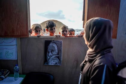 Los niños asisten a clases en una escuela improvisada en un campamento para palestinos desplazados en Deir El-Balah, en la franja central de Gaza