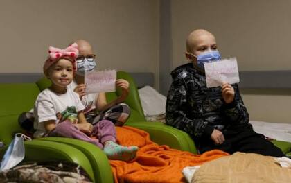 Los niños atendidos en el sótano del hospital de Kiev alzan carteles para pedir el fin de la guerra