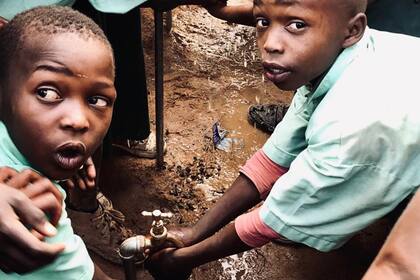 Los niños de la escuela rural de Kangundo, en Kenia, acceden a una canilla con agua