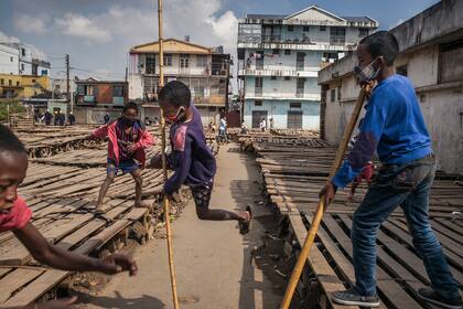 Los niños juegan en el mercado de ropa de segunda mano en el distrito de Isotry de la capital de Madagascar, Antananarivo, el 16 de mayo de 2020, donde 16 personas han sido infectadas con el coronavirus