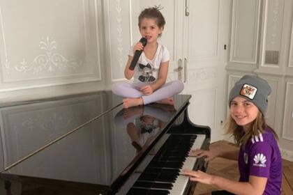 Los niños no sólo hacen la tarea, también se divierten cantando y tocando el piano.