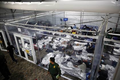 Los niños pequeños yacen dentro de una cápsula en el centro de detención del Departamento de Seguridad Nacional administrado por la Patrulla de Aduanas y Fronteras (CBP) el 30 de marzo de 2021 en Donna, Texas