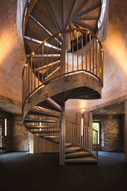 Los niveles de la construcción se unen a través de una gran escalera caracol: a medida que se asciende, el paisaje montañoso de los alrededores se integra al edificio