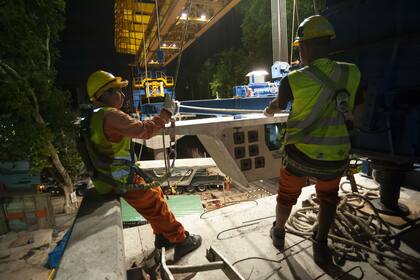 Los obreros trabajan con casco y arnés
