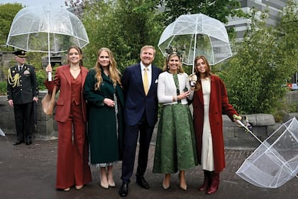 Los Orange posan para los fotógrafos, protegidos de la lluvia con paraguas transparentes.