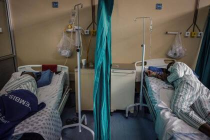 Los pacientes infectados de coronavirus COVID-19 yacen en cama en la sala número 20 del Hospital Tembisa, en Sudáfrica, el 2 de marzo de 2021