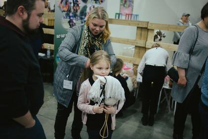 Los padres de Tiina Kaitala, de 7 años, la ayudan a prepararse para una competencia en Helsinki