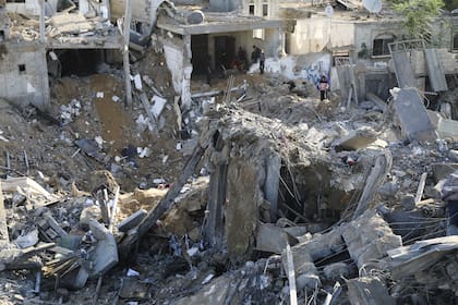 Los palestinos observan la destrucción causada por los bombardeos israelíes en la Franja de Gaza en Rafah, el lunes 4 de diciembre de 2023. 