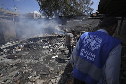 Los palestinos observan la destrucción después de un ataque israelí contra una escuela dirigida por la UNRWA, la agencia de las Naciones Unidas que ayuda a los refugiados palestinos, en Nuseirat, Franja de Gaza, 14 de mayo de 2024.