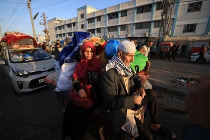 Los palestinos que se habían refugiado en refugios temporales regresan a sus hogares en el este de Khan Yunis, en el sur de la Franja de Gaza, durante las primeras horas de una tregua de cuatro días en las batallas entre Israel y los militantes de Hamas, el 24 de noviembre de 2023