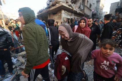 Los palestinos salen corriendo de una zona bombardeada en el campo de refugiados de Rafah, en el sur de la Franja de Gaza, el 1 de diciembre de 2023