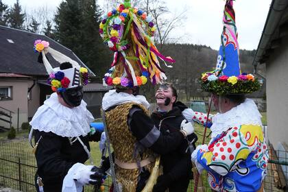 Los participantes del carnaval pintan la cara de un niño para celebrar la partida del invierno y la próxima primavera en el pueblo de Hamry, República Checa.